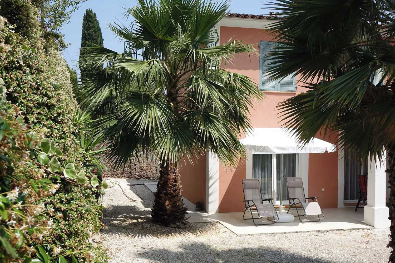 A building with a patio area, including a palm tree and outdoor seating.