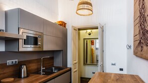 A compact kitchen with a built-in microwave, stainless steel sink, and wooden countertop. - Dolce Suite Near Syracuse Cathedral by Wonderful Italy (Syracuse)