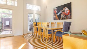 A dining area with a table, chairs, and a glass-top coffee table.