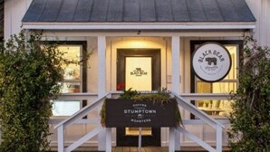 A building with a sign reading "Bread BLACK BEAR Company" and another sign below it stating "Coffee Stumptown Roasters". - 30A Cottage, Walk to Beach, 2 Pools, Bikes&Chairs (Santa Rosa Beach)