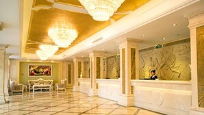 A spacious lobby with a check-in counter, ornate chandeliers, and a large mural on the wall. - Vienna Hotel Ningbo Jiangbei Avenue Wanda Branch (Ningbo)