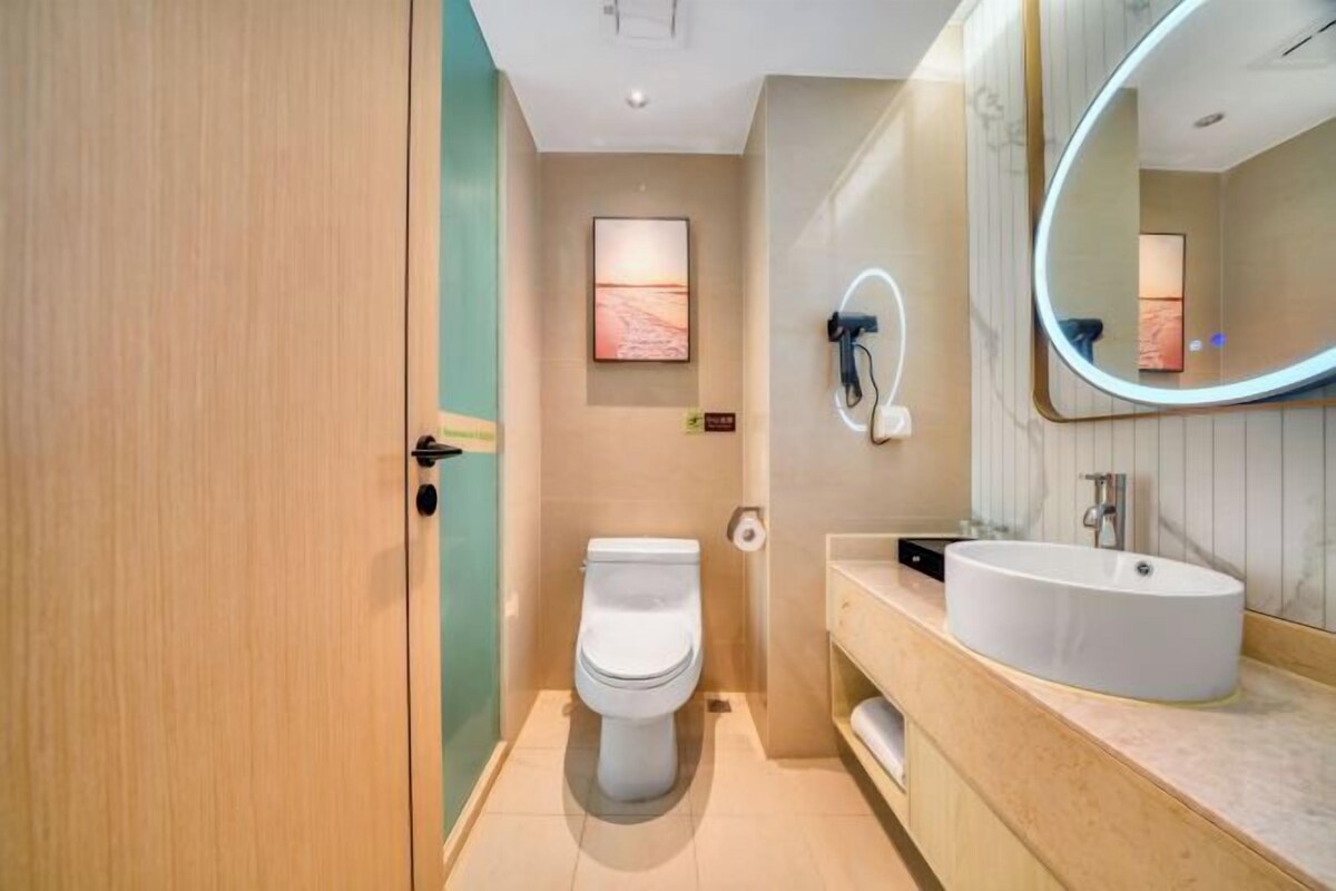 A modern bathroom with a toilet, sink, and mirror.