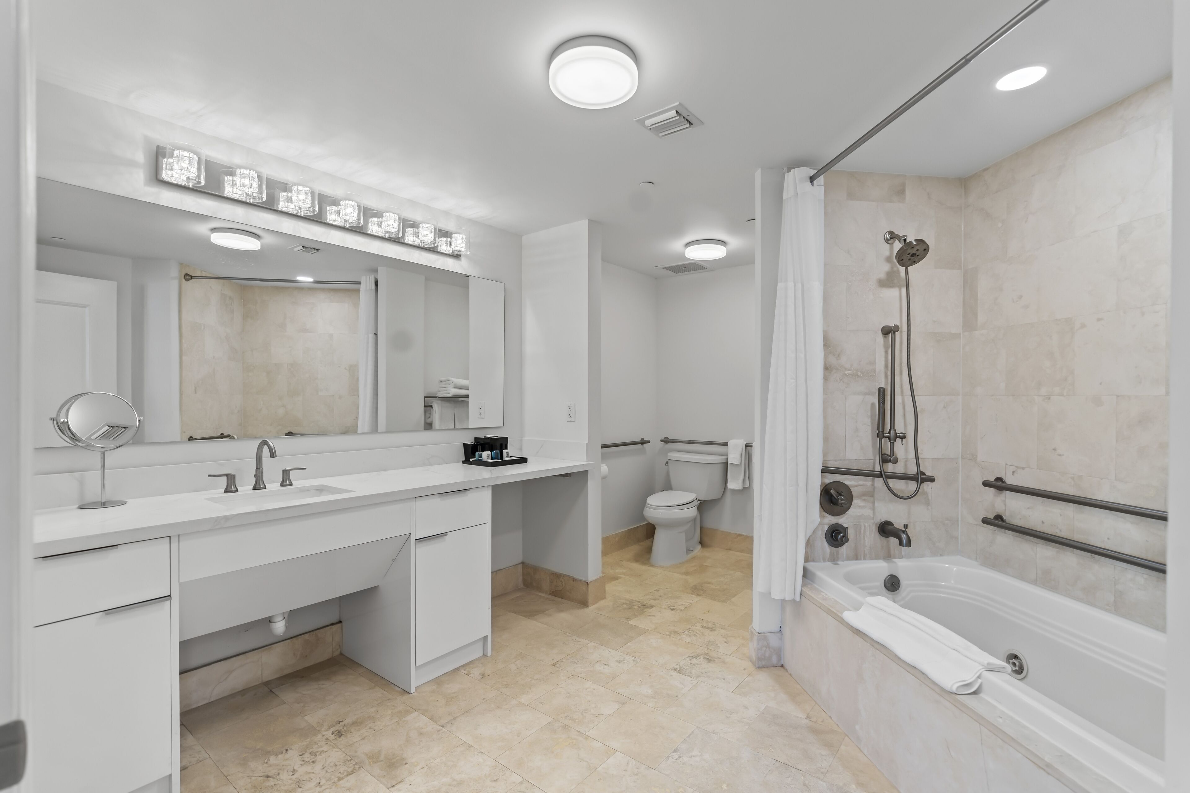 A modern bathroom with a white vanity, a large mirror, a bathtub, and a shower.