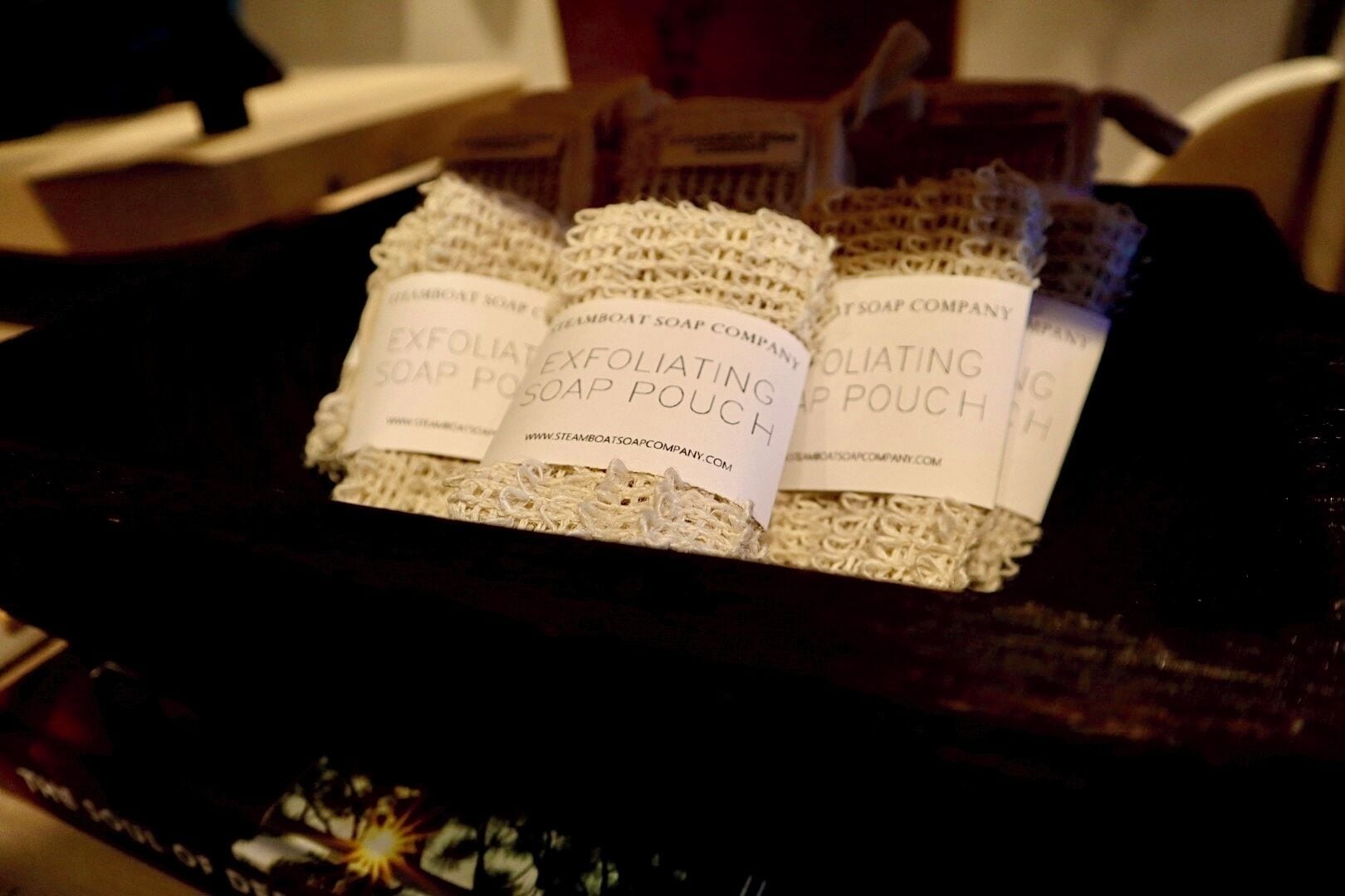 A tray of soap pouches labeled 'Exfoliating Soap Pouch' from Steamboat Soap Company.