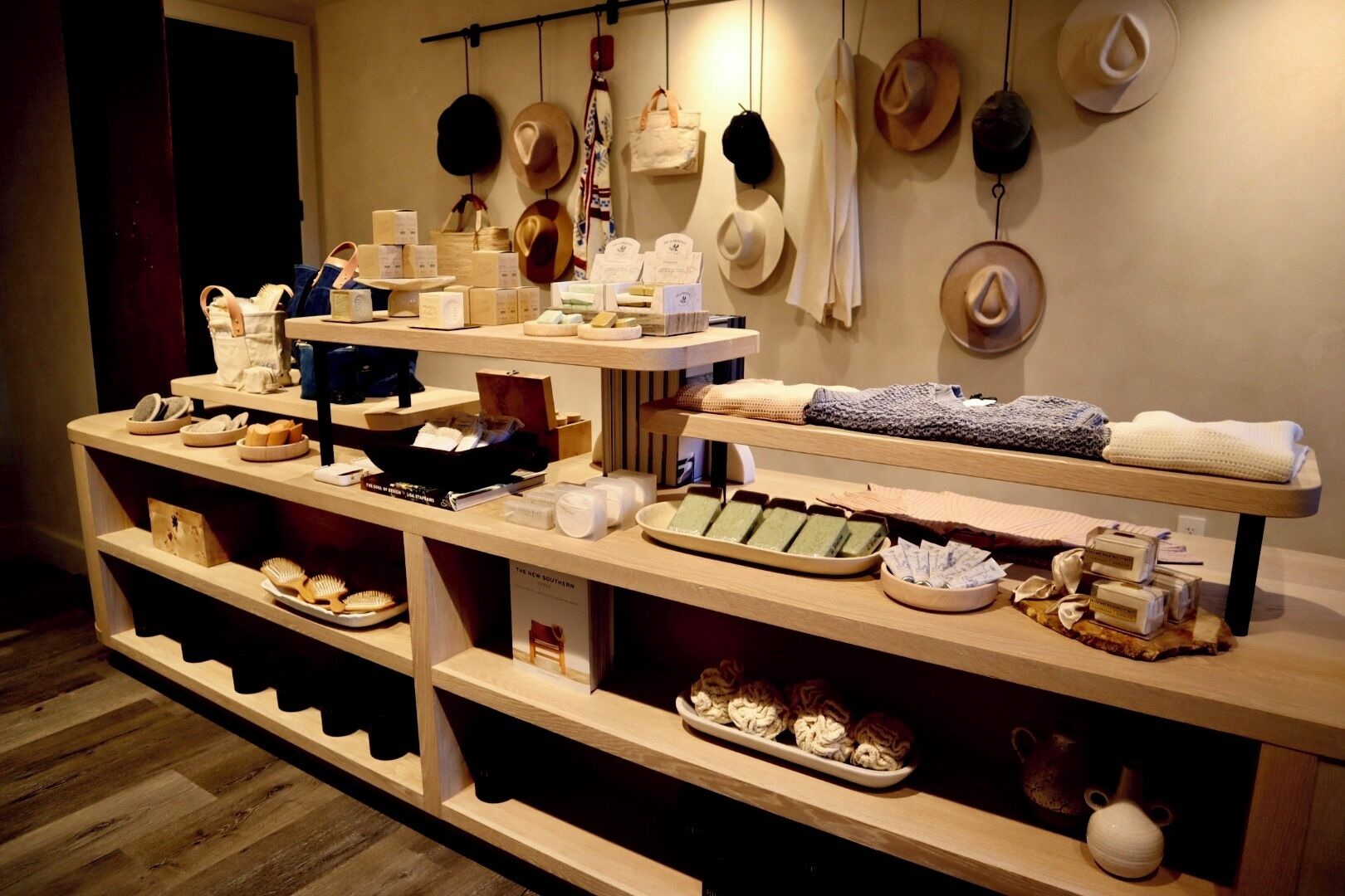 Una exhibición de sombreros y accesorios en estantes y colgados en la pared.