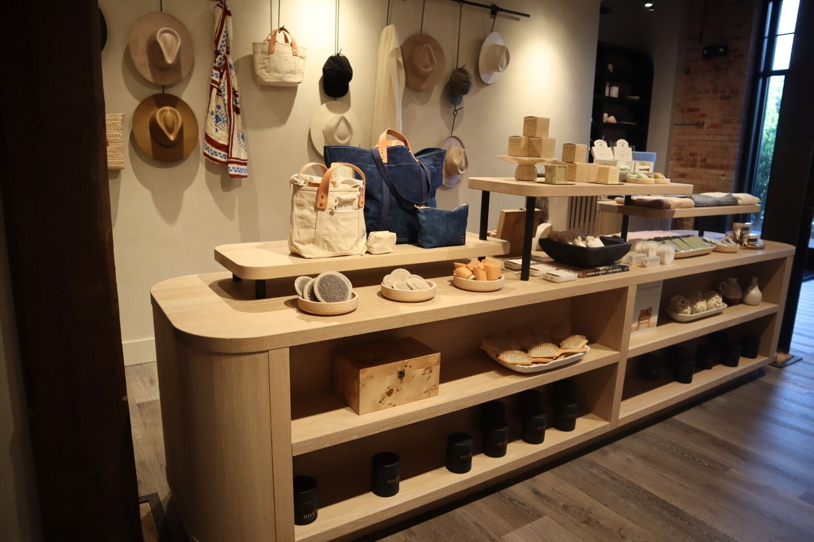 Tienda con estantes de madera que exhiben sombreros, bolsos y artículos de tocador.