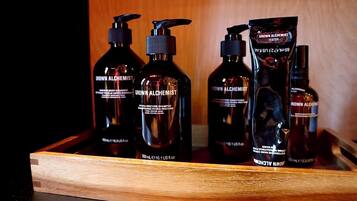 A wooden tray holding various bottles of 'Grown Alchemist' skincare products.