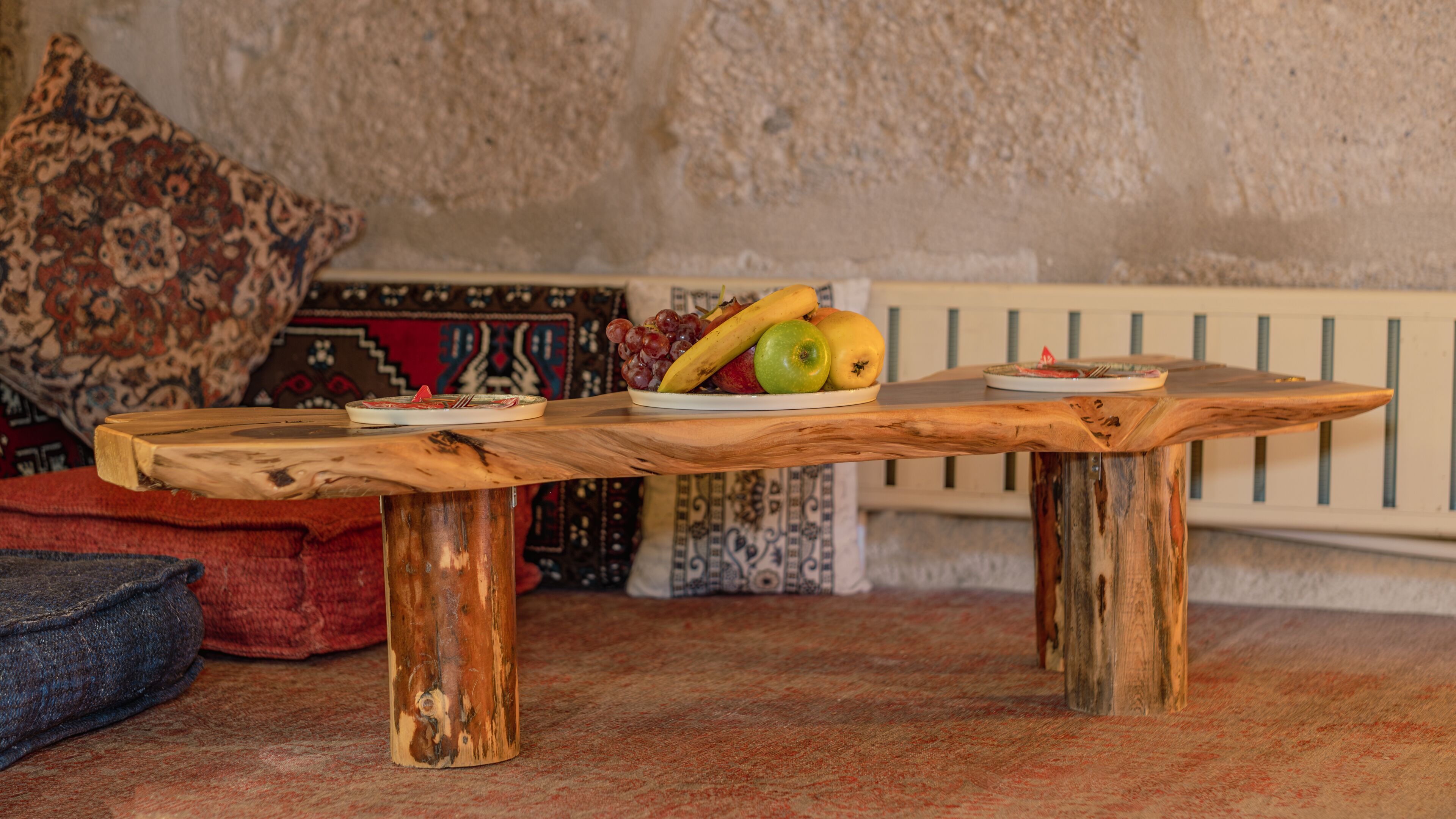 Uma mesa de madeira rústica com uma travessa de frutas e um prato de comida.