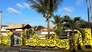 A yellow wall with a palm tree and the text "Chales Centro de Pipa". - CHALÉS CENTRO DA PIPA (Tibau do Sul)