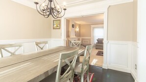 Ein Essbereich mit Holztisch und Stühlen, einer Kandelaber und einem Gemälde an der Wand.