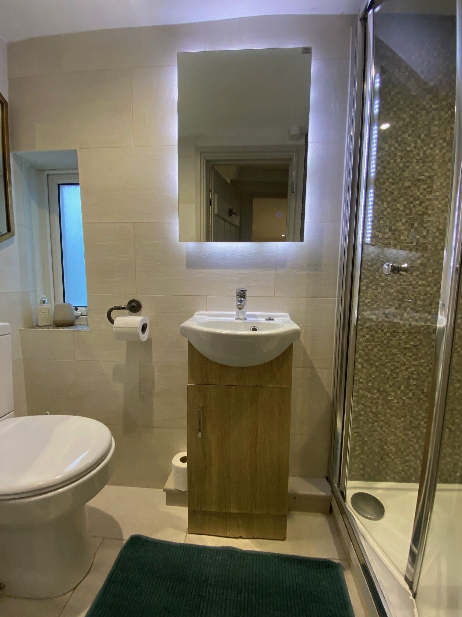 A bathroom with a toilet, sink, and shower.