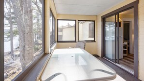 Una habitación con una mesa grande, puertas de vidrio correderas y vista a un cuerpo de agua.