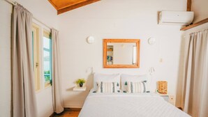 A bedroom with a bed, a wooden ceiling, a mirror, a bedside table, and a window with curtains. - AMAZING Ensenada Honda View @ MAREA 2-2 - Punta Aloe #3 (Culebra)