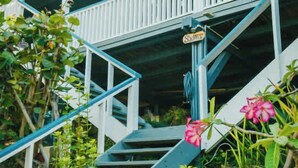A multi-level staircase with a blue railing, surrounded by greenery and pink flowers. - AMAZING Ensenada Honda View @ MAREA 2-2 - Punta Aloe #3 (Culebra)