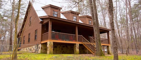 A cabin with a stone foundation, wooden exterior, and multiple levels with balconies.