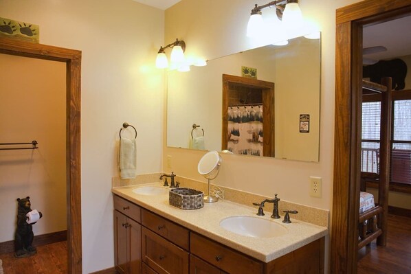 A bathroom with two sinks, a mirror, and a wooden cabinet.