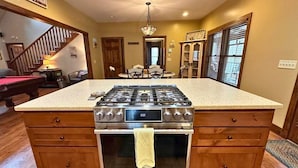 Une cuisine dotée d’un îlot central, d’une cuisinière, d’un four et de meubles de rangement en bois.