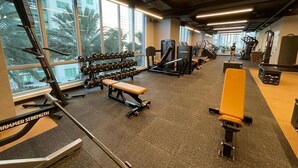 Une salle de sport équipée de matériel de musculation, de tapis de course et d’haltères.
