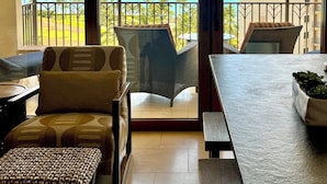 A balcony with a view of the ocean and a building across the street.