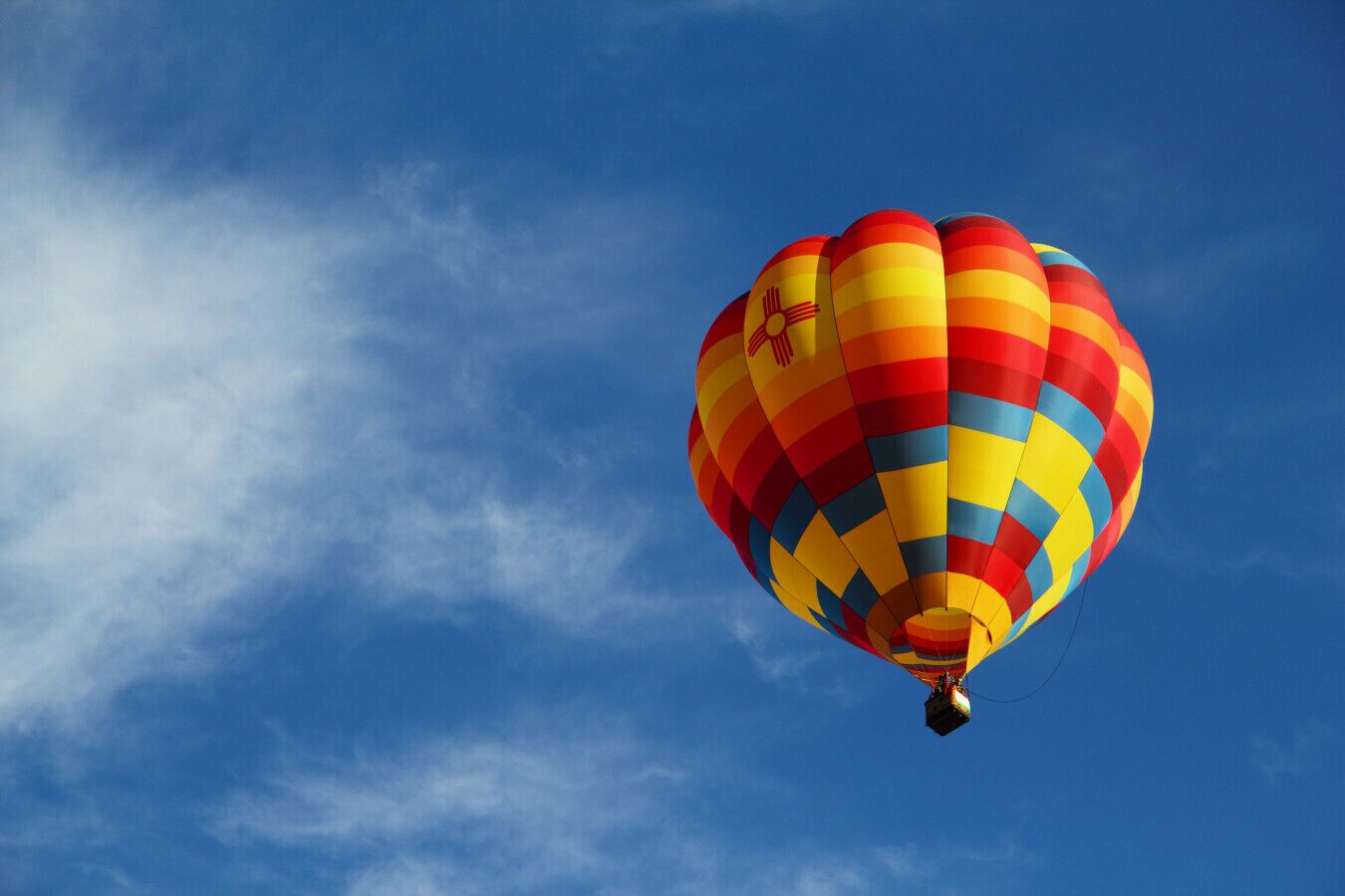 A hot air balloon with a checkered pattern against a clear blue sky.