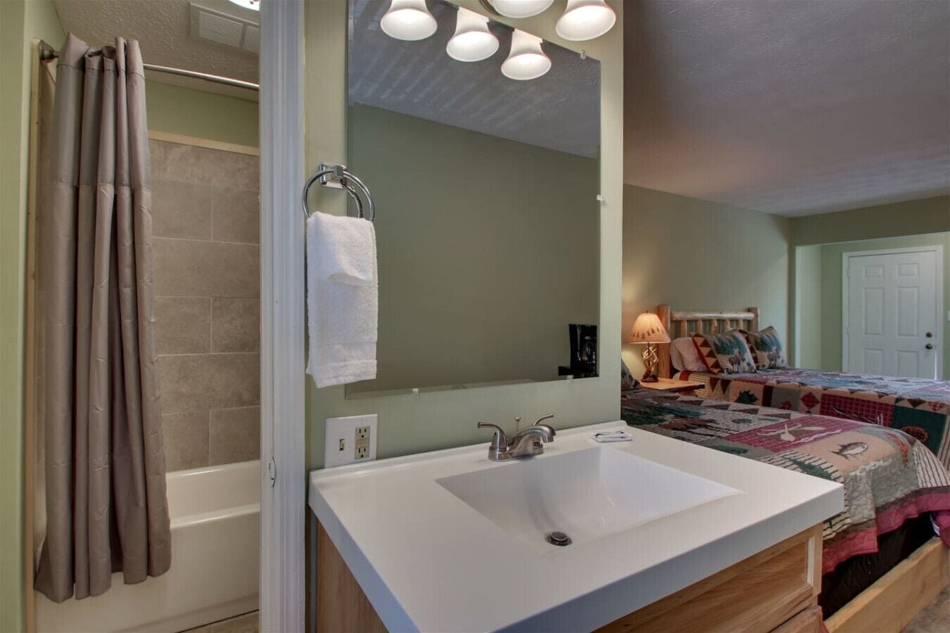 A bathroom with a white sink, a towel rack, and a shower curtain.