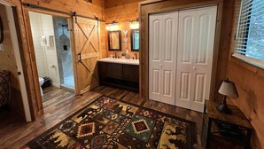 A wooden interior with a bathroom, a sink, and a patterned rug. - Bavarian Hideaway 25 (Sautee Nacoochee)