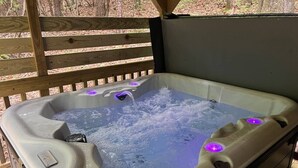 A hot tub with water jets, a control panel, and a wooden deck in the background. - Bavarian Hideaway 25 (Sautee Nacoochee)