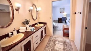 A bathroom with two sinks, a large mirror, and wall sconces. - Neat & Tidy Private Entry Cozy Suite in Dayton Area with a Dedicated AC (Dayton)