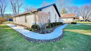 A single-story brick house with a small front yard, a curved driveway, and a clear blue sky. - Neat & Tidy Private Entry Cozy Suite in Dayton Area with a Dedicated AC (Dayton)