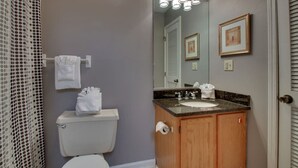 Une salle de bain équipée de toilettes, d’un lavabo et d’un rideau de douche.