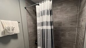 Une salle de bain équipée d’une douche, de toilettes et d’un porte-serviettes avec des serviettes.