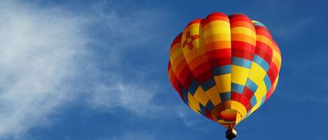 A hot air balloon with a checkered pattern against a clear blue sky.