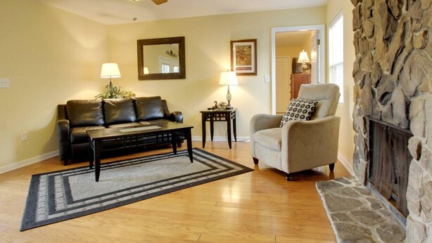 A living room with a sofa, armchair, coffee table, and fireplace. - Bavarian Brook Condo 15 (Helen)