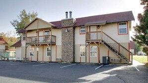 A two-story building with a stone facade, a balcony on the upper floor, and a staircase leading to the upper level. - Bavarian Brook Condo 15 (Helen)