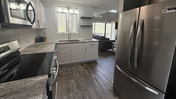 Een moderne keuken met roestvrijstalen apparatuur, witte kasten en een groot keukenblok.