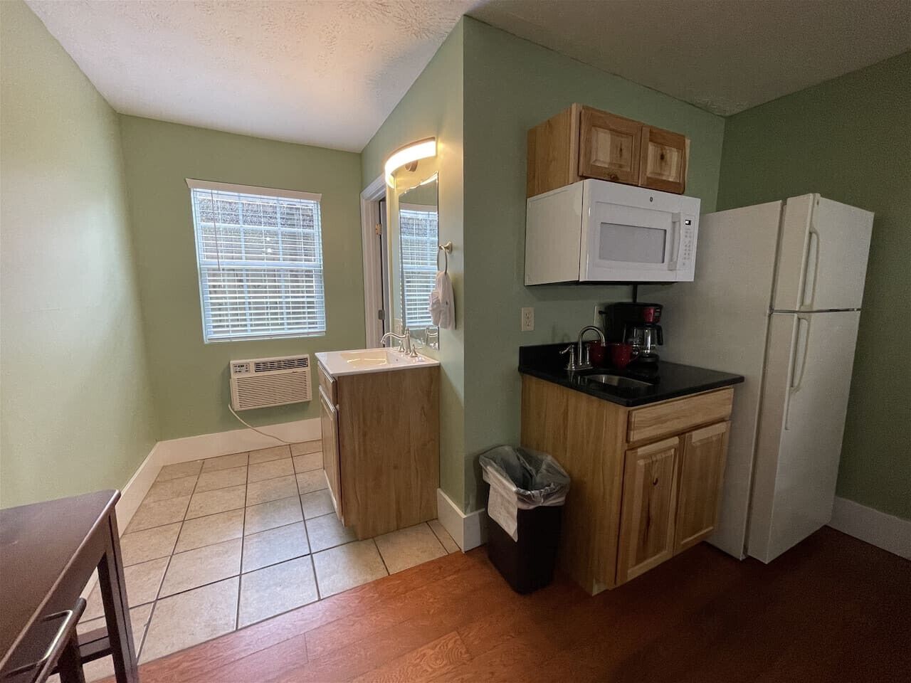 A compact kitchen with a sink, microwave, and refrigerator.