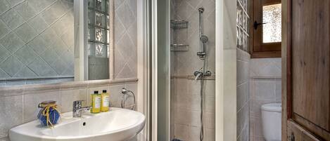 A bathroom with a white sink, a glass shower enclosure, and a toilet.