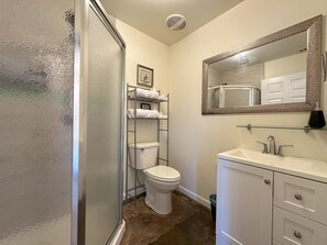 A bathroom with a shower, toilet, and sink.