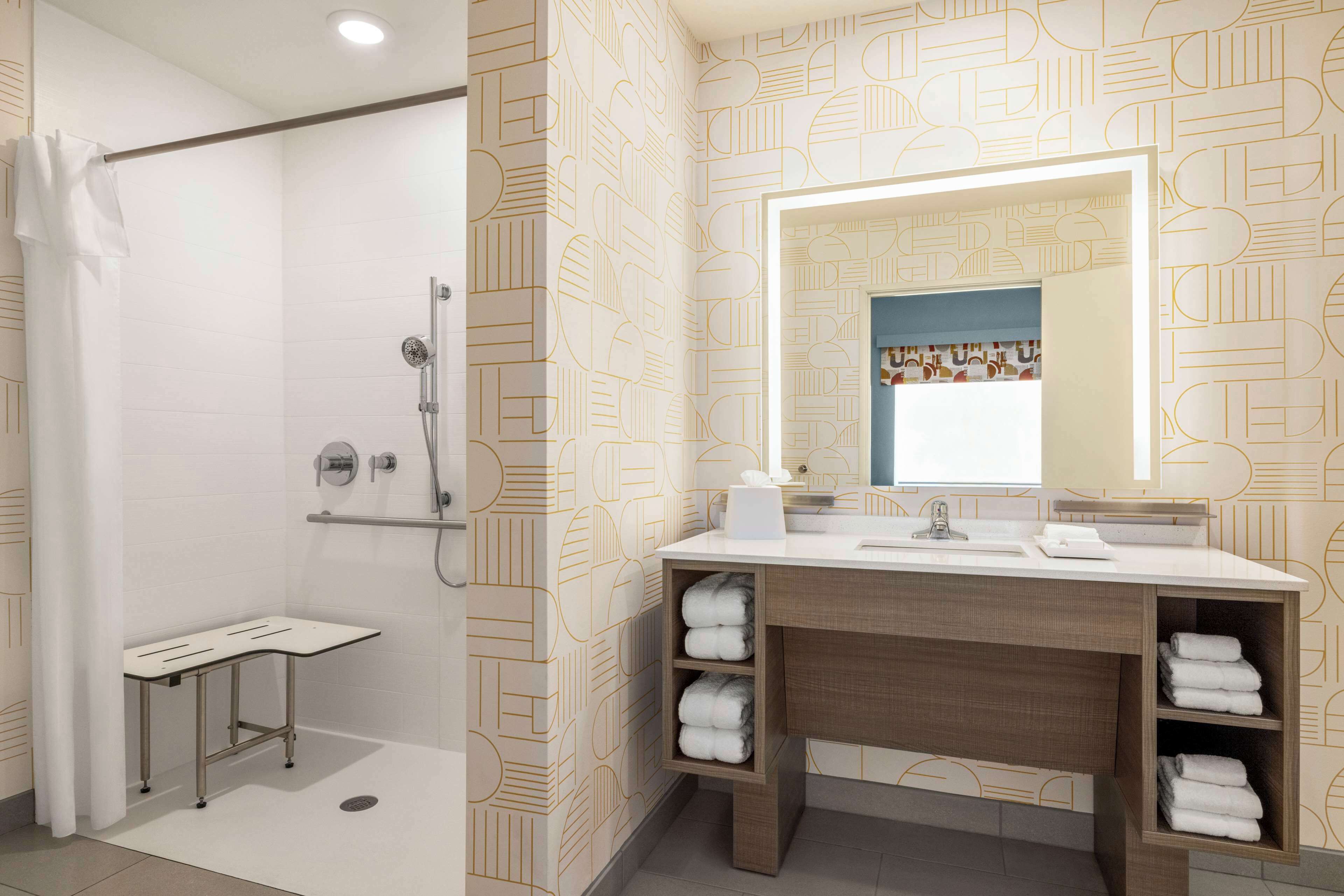 A modern bathroom with a shower, a vanity with a mirror, and shelves for towels.