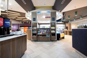 Ett modernt försäljningsområde med ett centralt placerat stånd, olika produktdisplayer och en kaffestation.