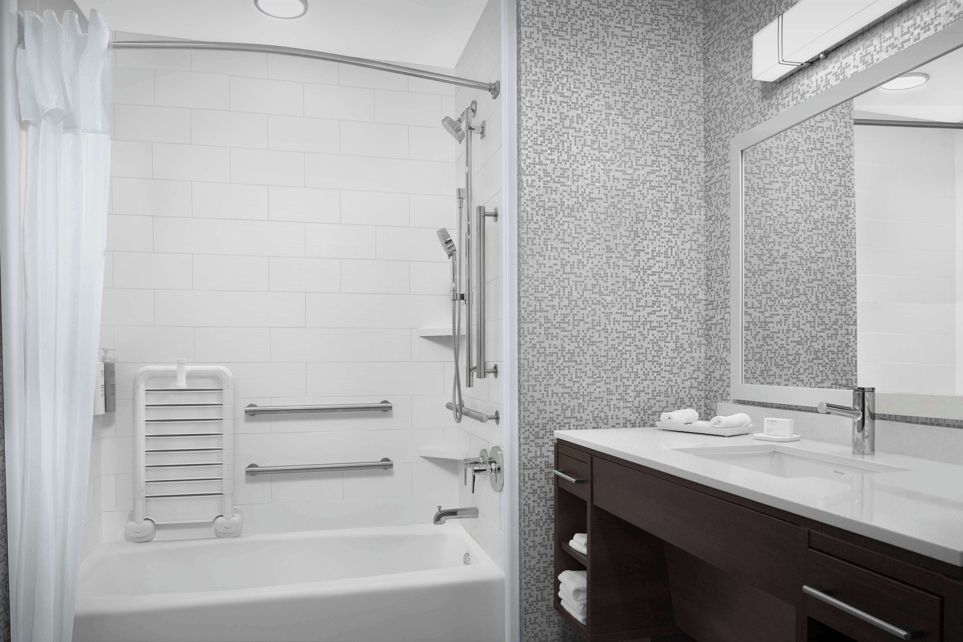 A modern bathroom with a shower, a sink, and a vanity.