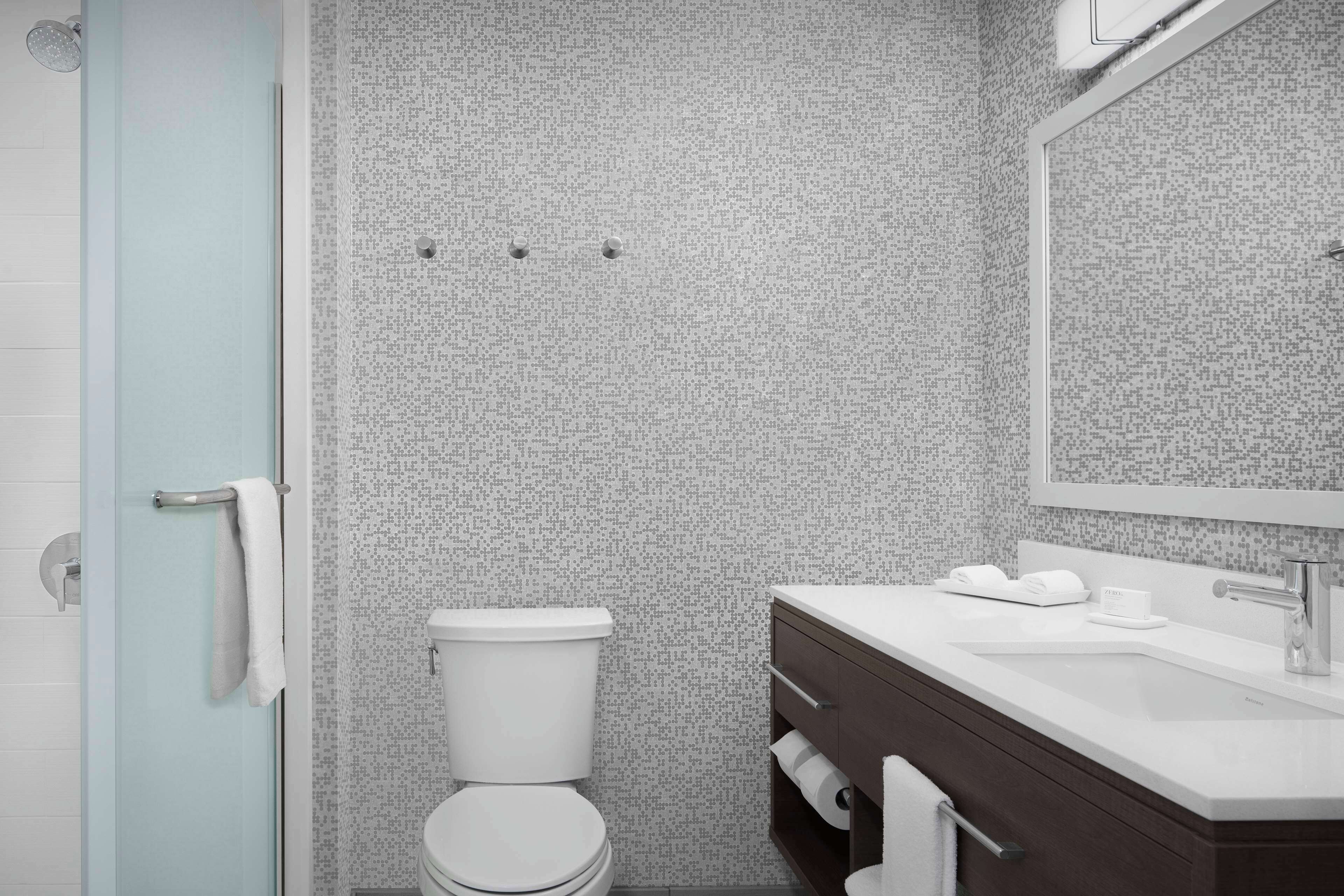 Une salle de bain moderne équipée de toilettes, d’un lavabo et d’une douche.