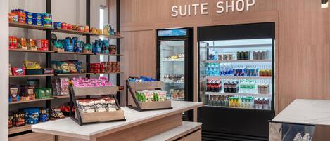 Una tienda de suites con estantes llenos de bocadillos y un refrigerador con bebidas.