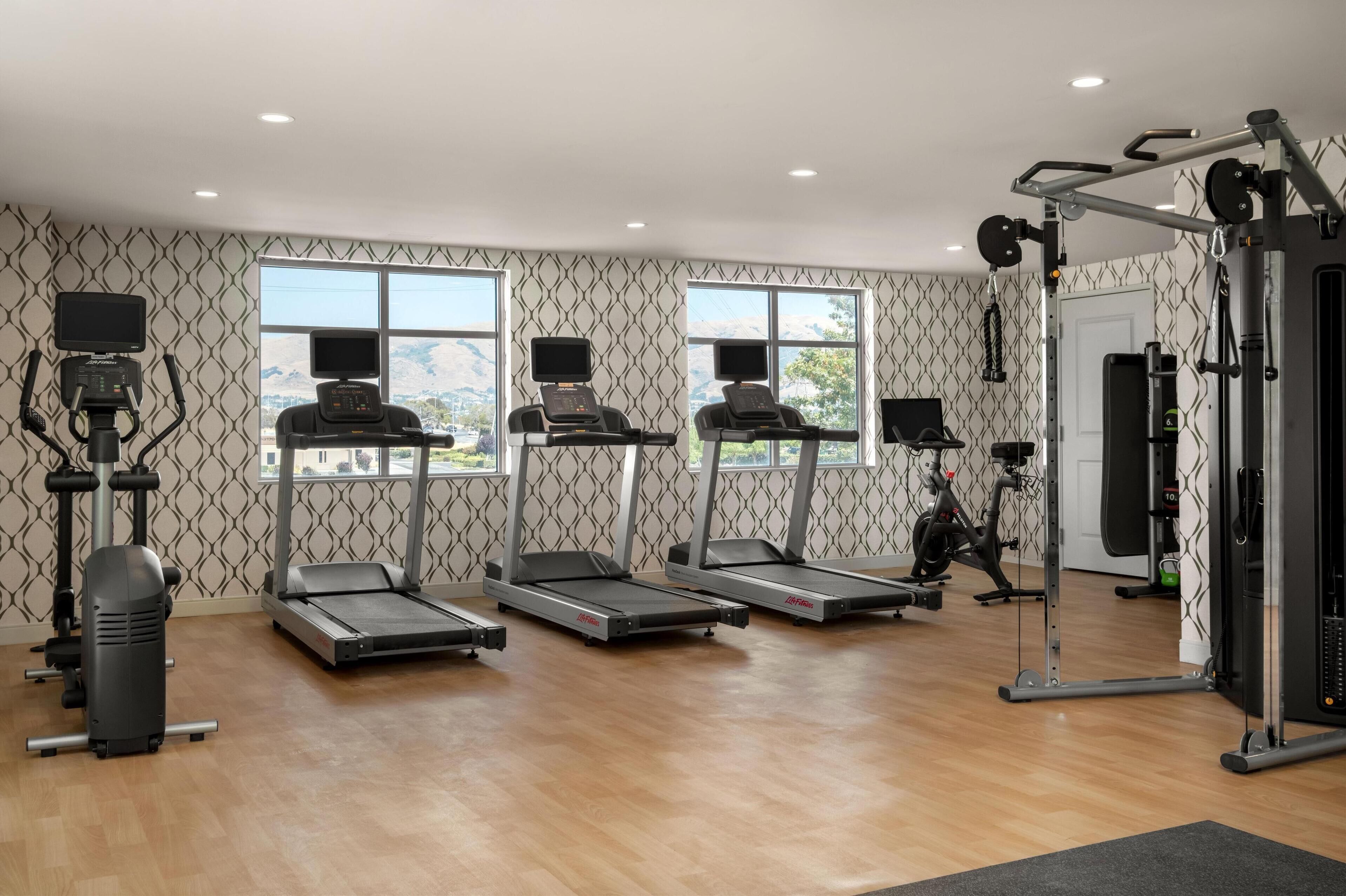 A gym with treadmills, a weight machine, and a stationary bike.