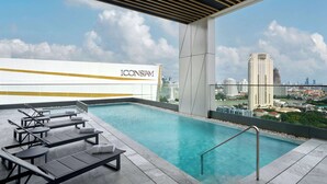 A rooftop infinity pool with lounge chairs and a city view. - Hilton Garden Inn Bangkok Riverside (Bangkok)
