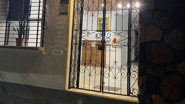 A hostel with a metal gate and a sign that reads "HOSTAL POCHOTE". - Hostal Pochote  (León)
