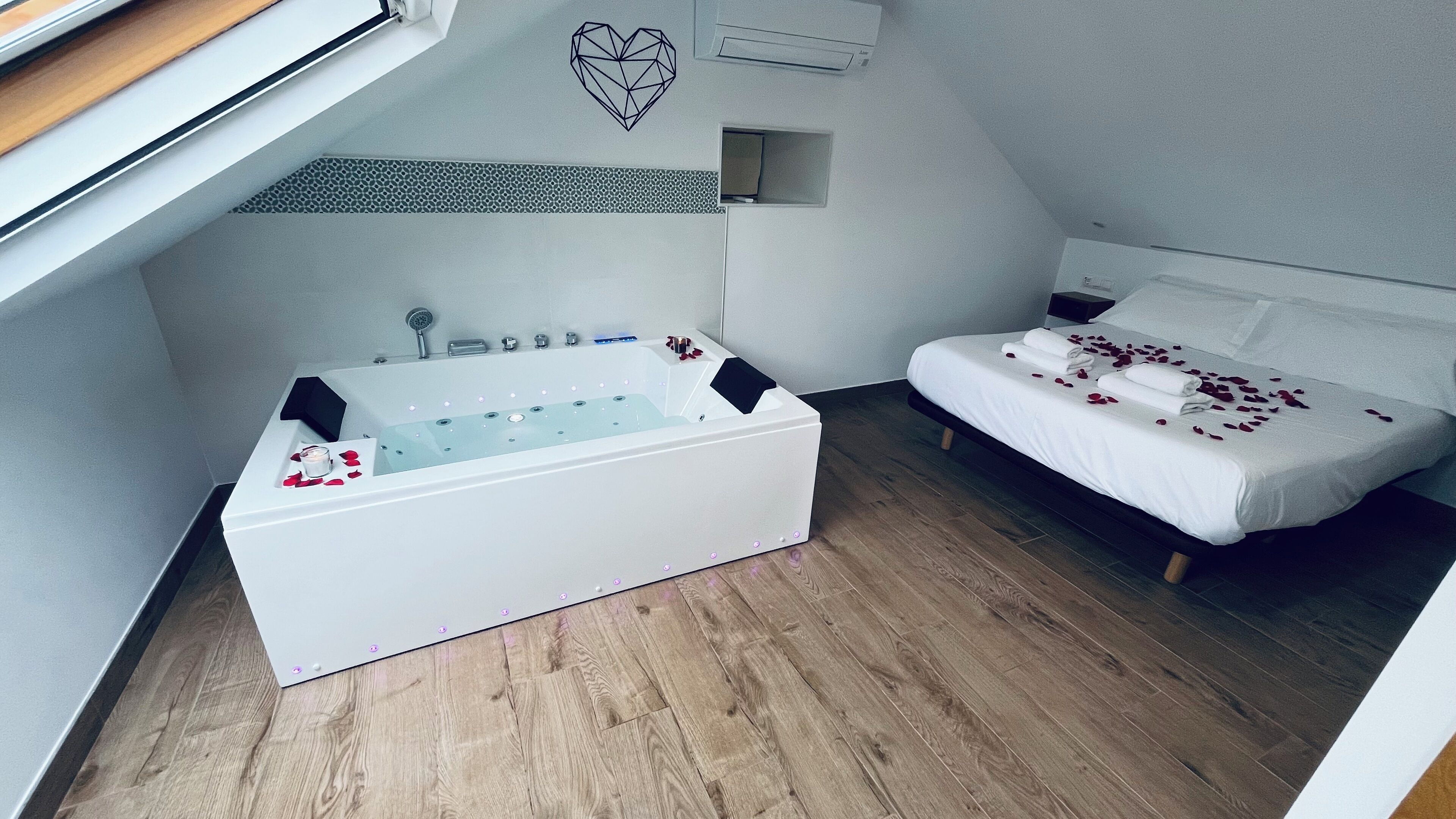 Une salle de bain moderne avec une baignoire, une douche et une petite fenêtre.