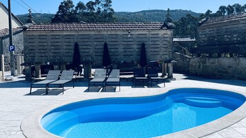 季节性开放的室外游泳池，10:00 至 22:00 开放，池畔遮阳伞，日光浴躺椅