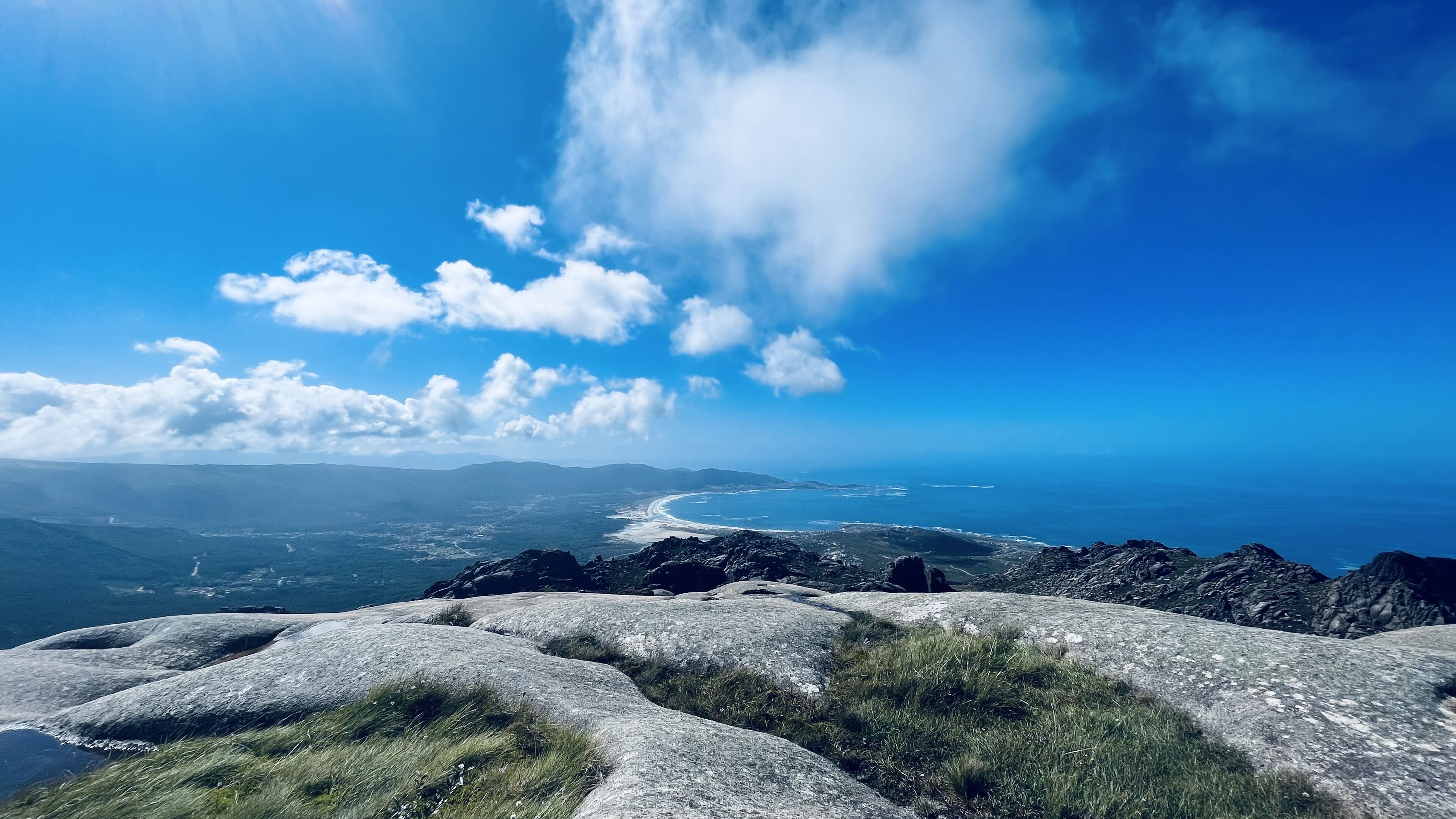 Paisaje costero con terreno rocoso y vista al océano.