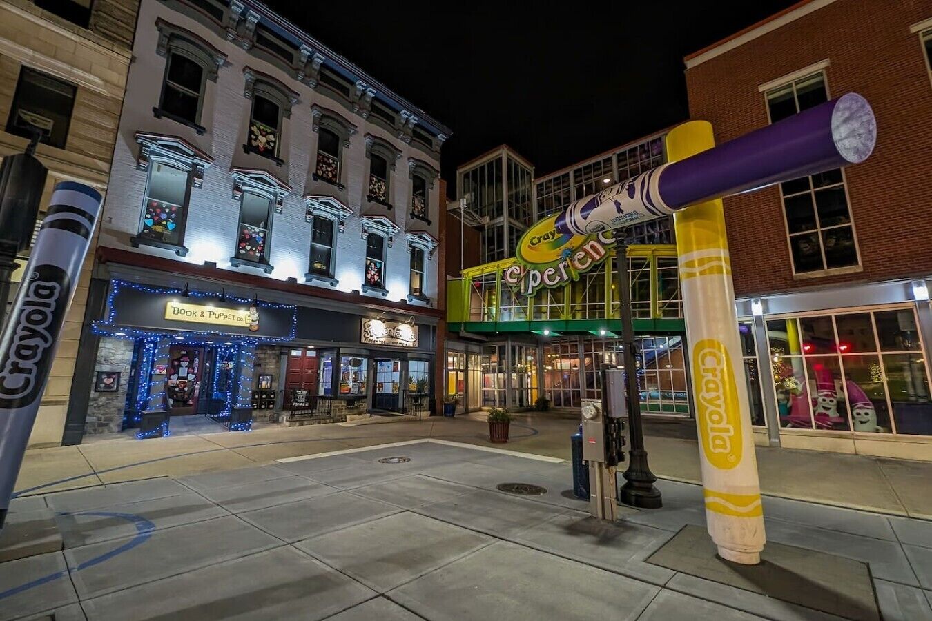 Une rue bordée d’immeubles, dont un magasin avec une enseigne indiquant « Crayola » et un autre avec une enseigne indiquant « Ciperco ».